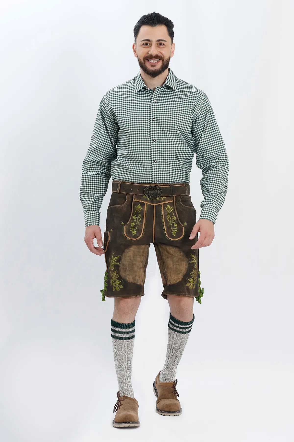 Lederhosen Men in Dark Brown Color with Traditional Embroidery. Model is wearing Green Checkered Traditional Shirt with Bavarian Socks and Shoes.